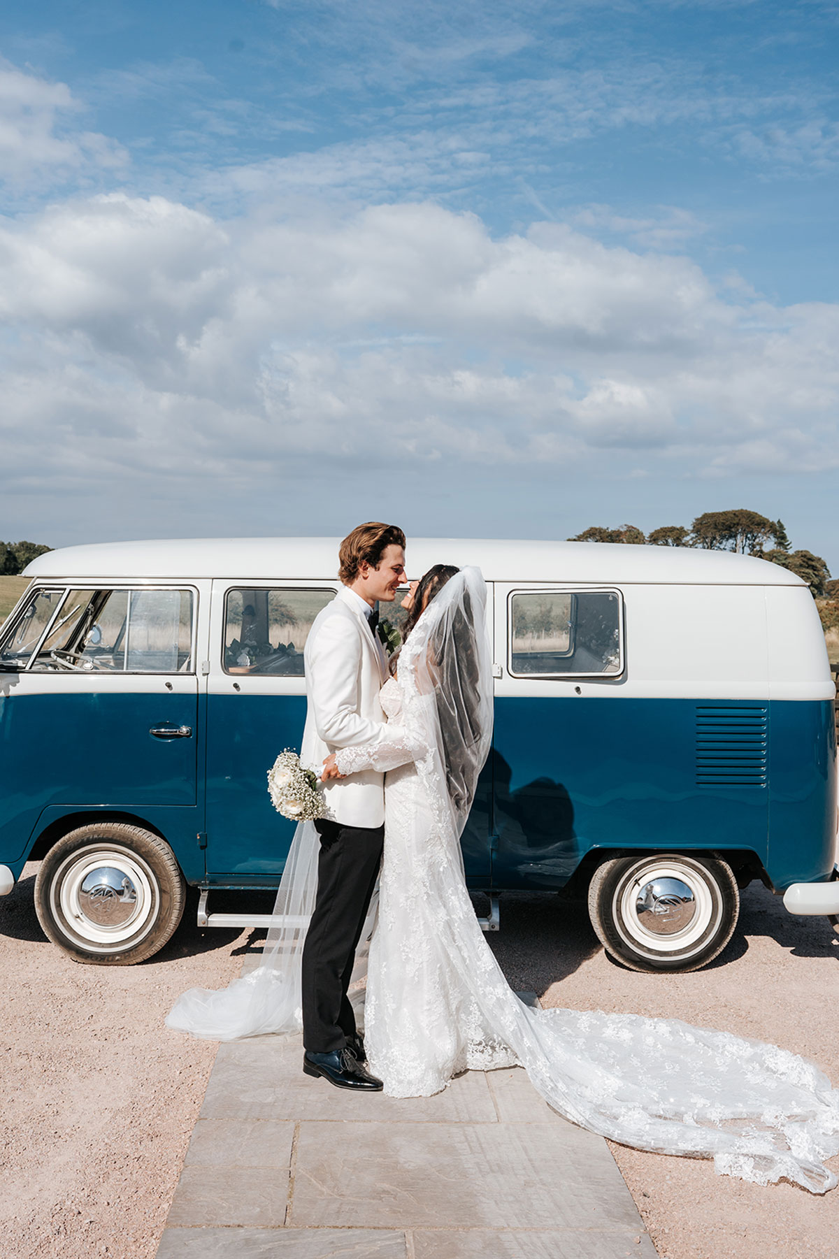 Bride and groom posing beside a blue vintage camper van, Scottish wedding portrait