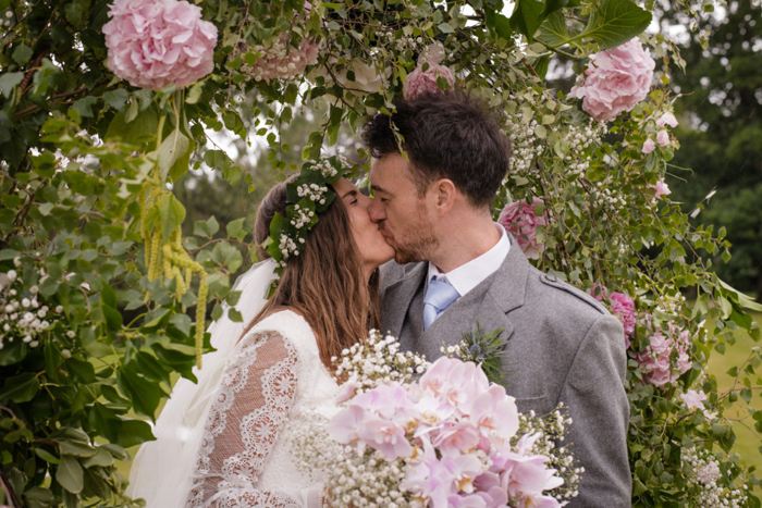 A Bride And Groom Kissing In The Garden At Raemoir House