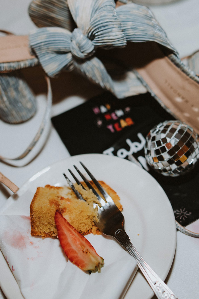 flatlay of wedding items including blue shoes and wedding cake