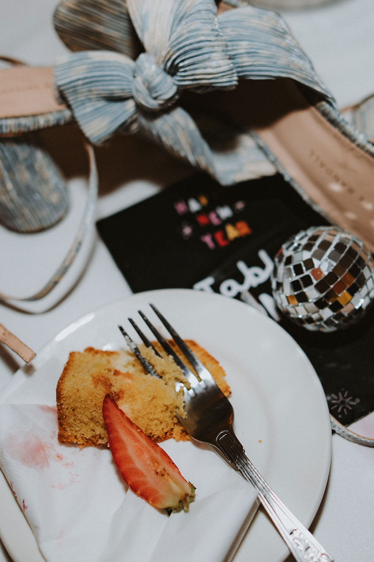 flatlay of wedding items including blue shoes and wedding cake