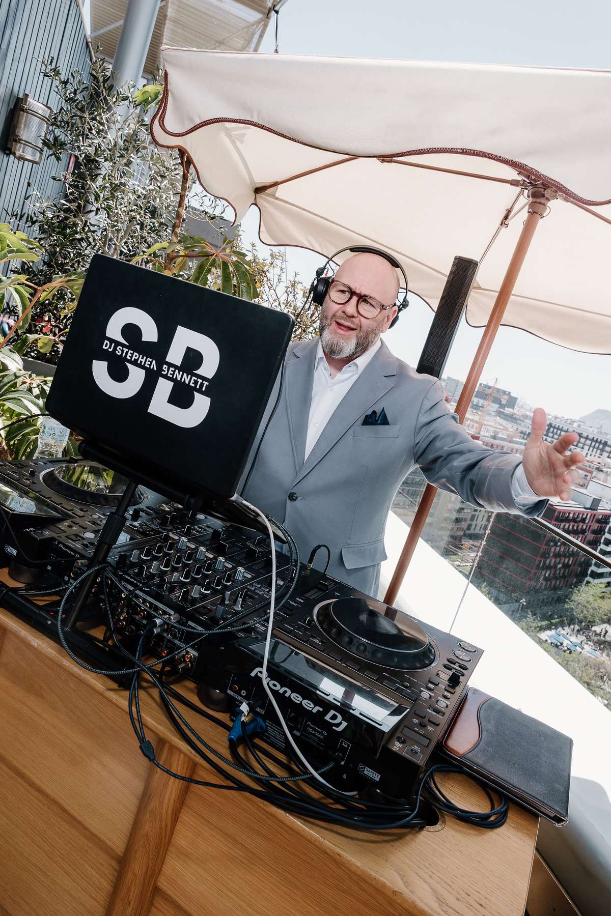 Wedding DJ Stephen Bennett performs behind the decks at the rooftop wedding celebration at The Hoxton Barcelona.