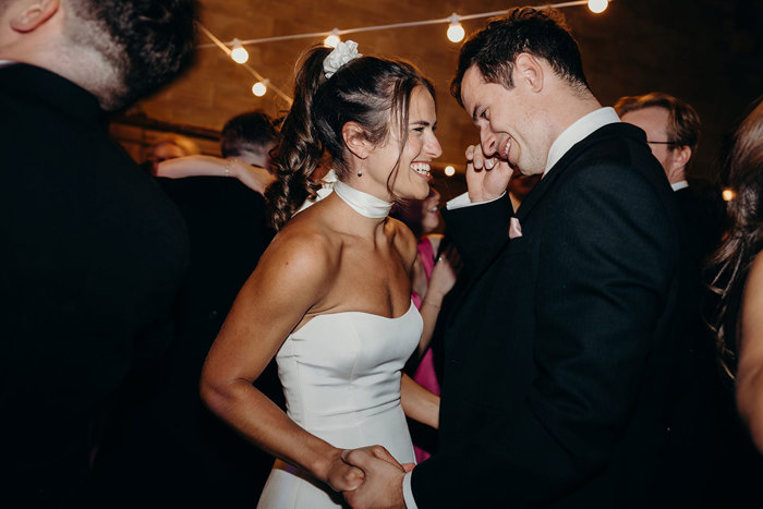 a smiling bride and groom dancing