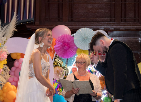 Bride and groom laugh during their wedding ceremony at St Luke's Glasgow