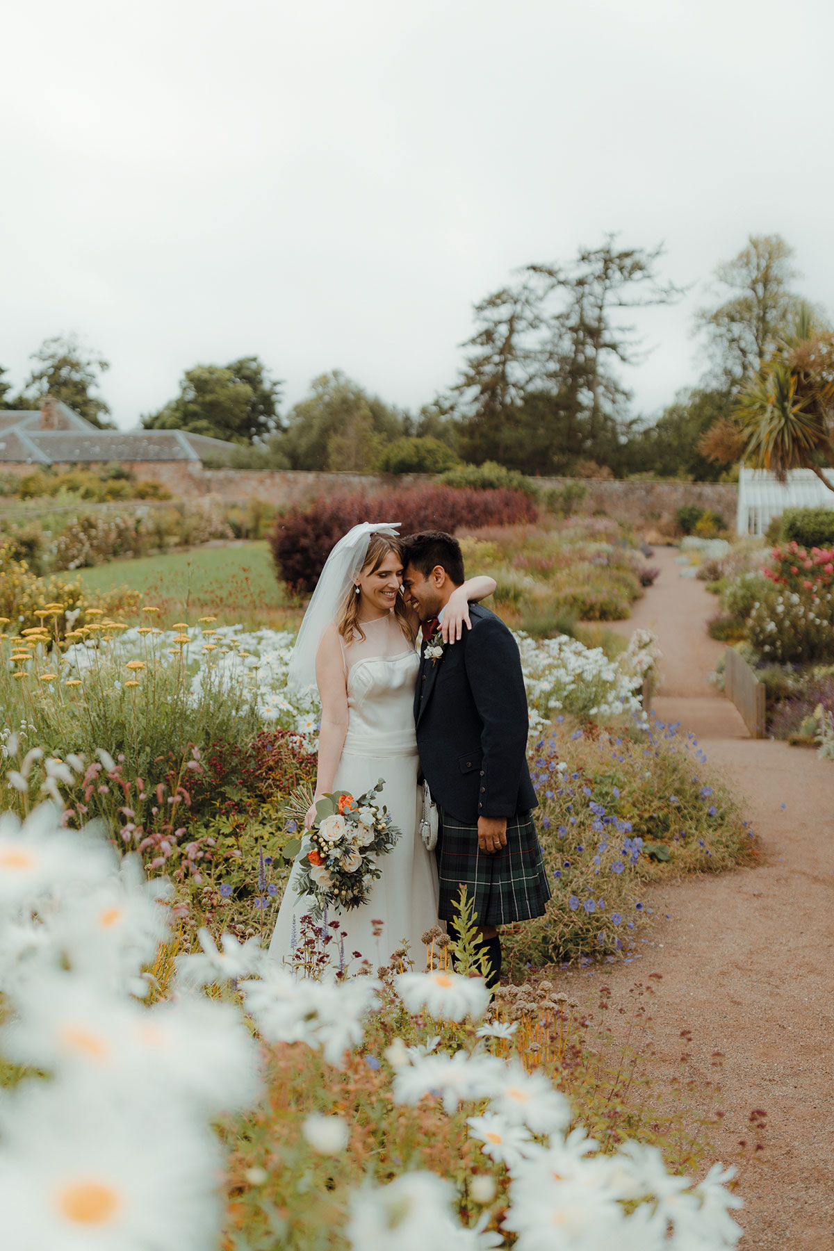Bride and groom in Cambo Estate walled garden surrounded by flowers, Fife wedding portrait