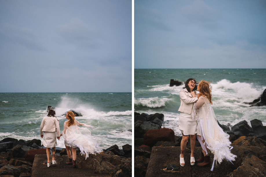Two Brides Posing On Rocks By The Sea