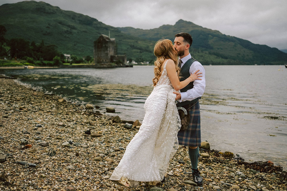 Carrick Castle Estate Argyll lochside wedding venue bride and groom kissing on shore of Loch Goil