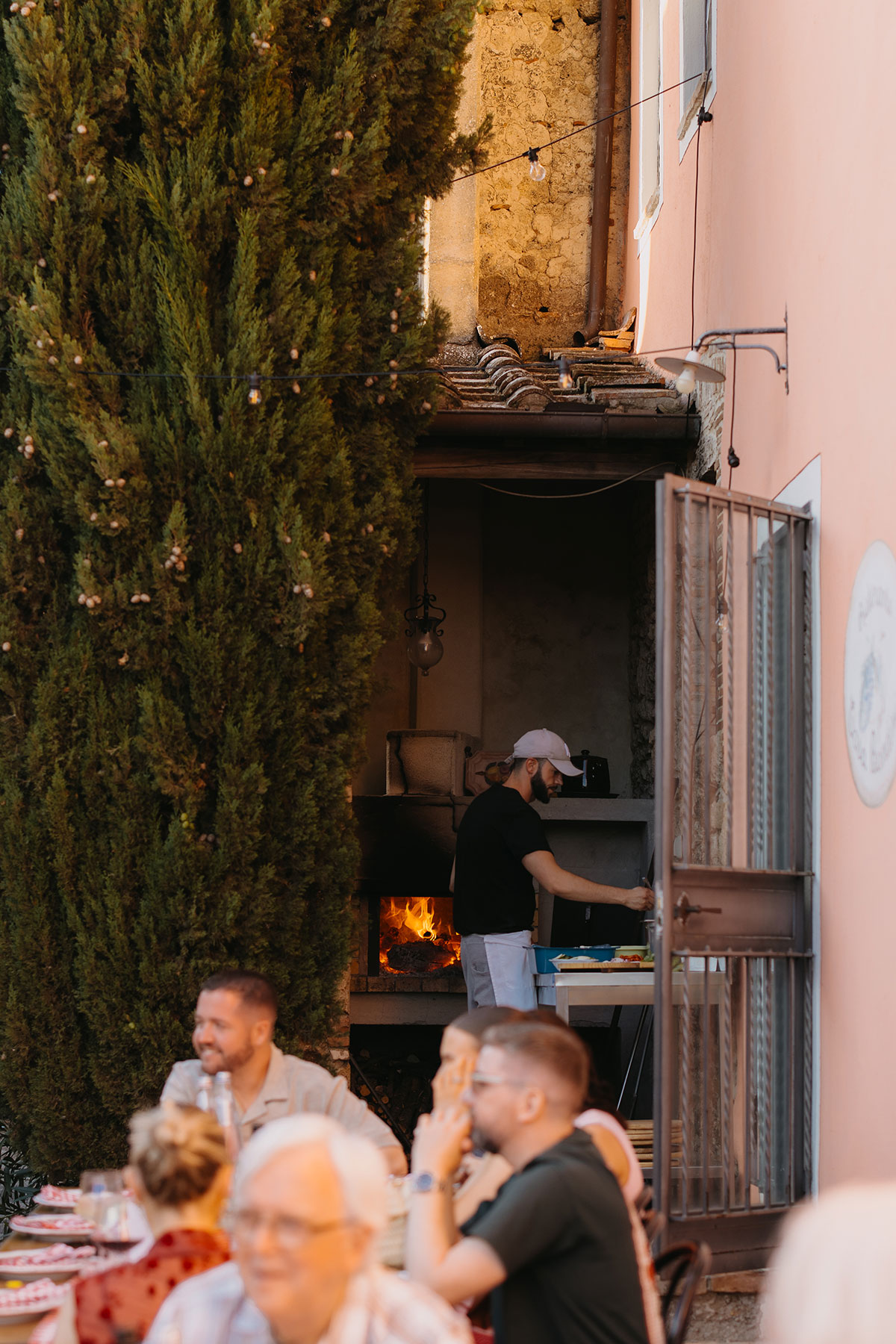 Chef preparing wood-fired pizza at wedding welcome party at Antico Borgo San Lorenzo Tuscany