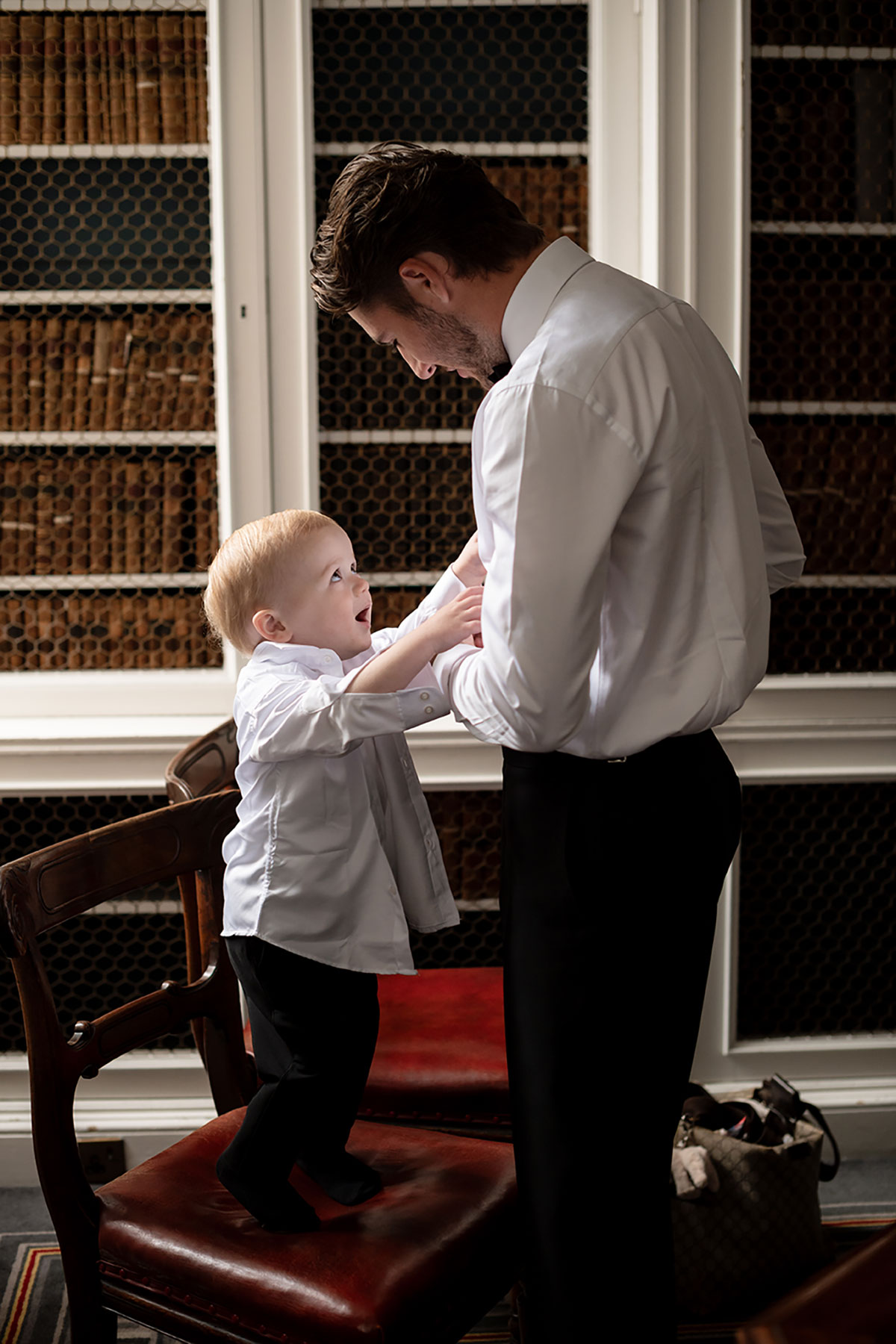 Groom helping toddler get ready in The Signet Library