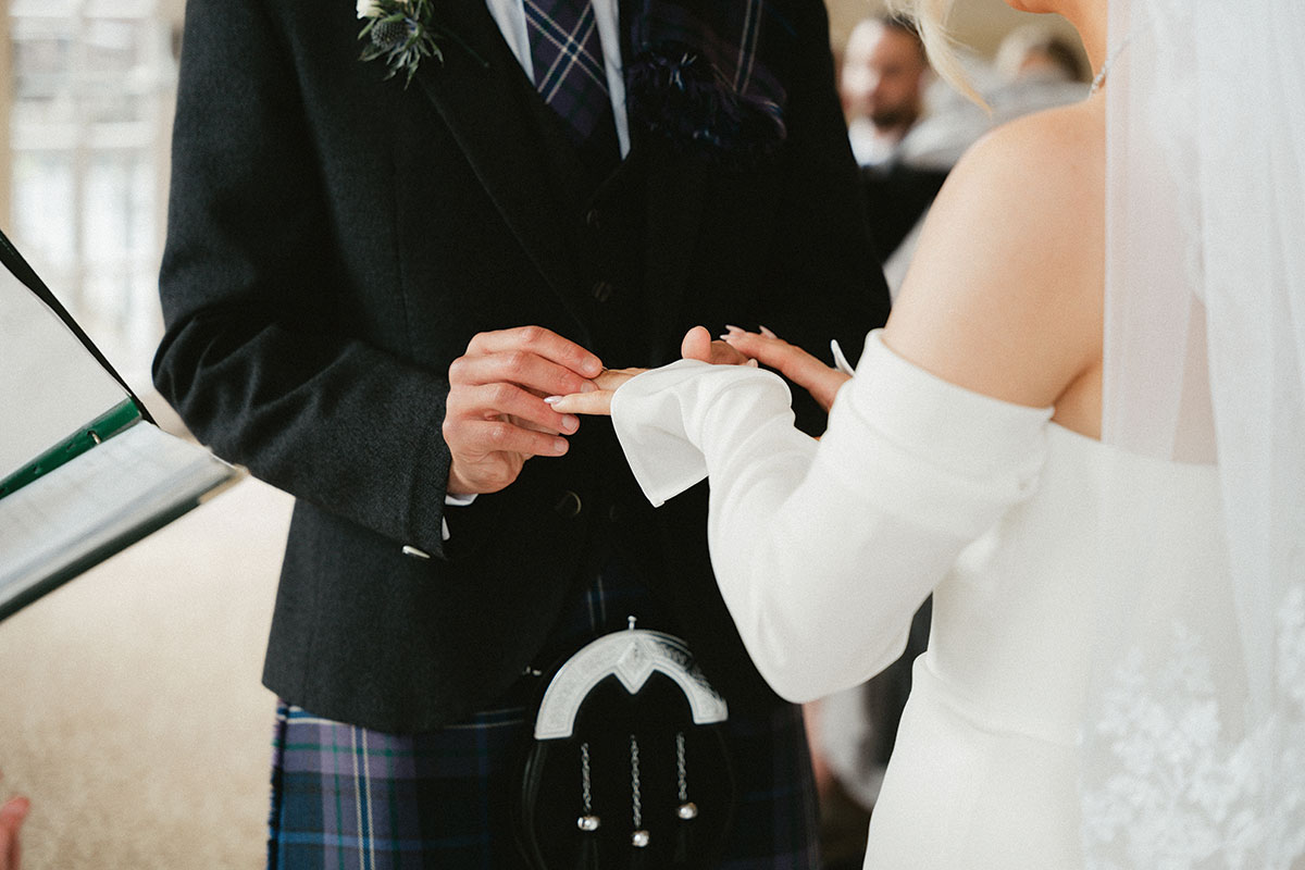 Bride and groom exchanging wedding rings during a Scottish wedding ceremony
