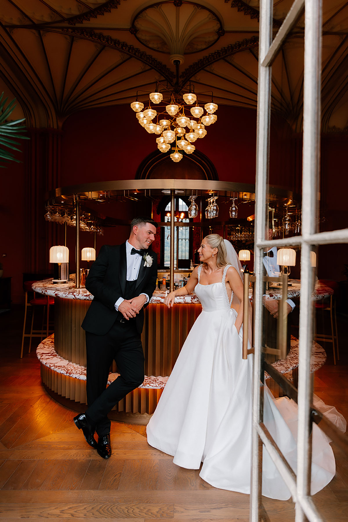 Bride and groom chatting and posing together in the stylish bar area at Mar Hall.
