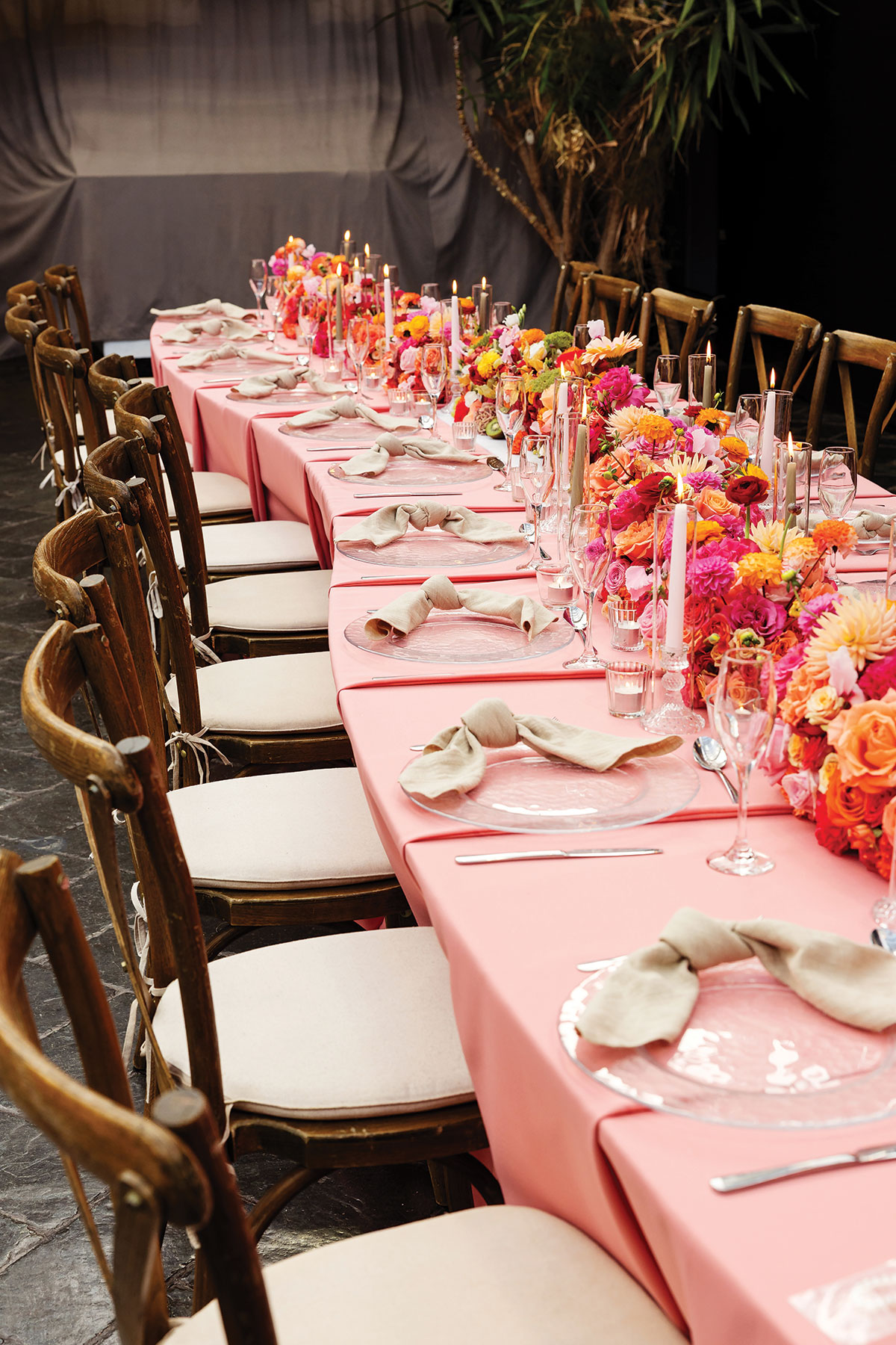Long banquet table with pink linen and vibrant floral styling for modern wedding reception at BAaD