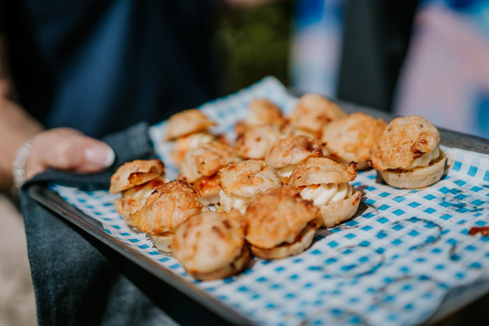 A tray of filled scones on a blue and white checkered canapé tray