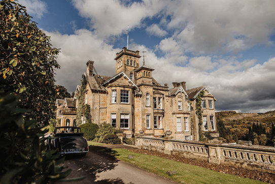 Auchen Castle exterior with a car parked in the driveway