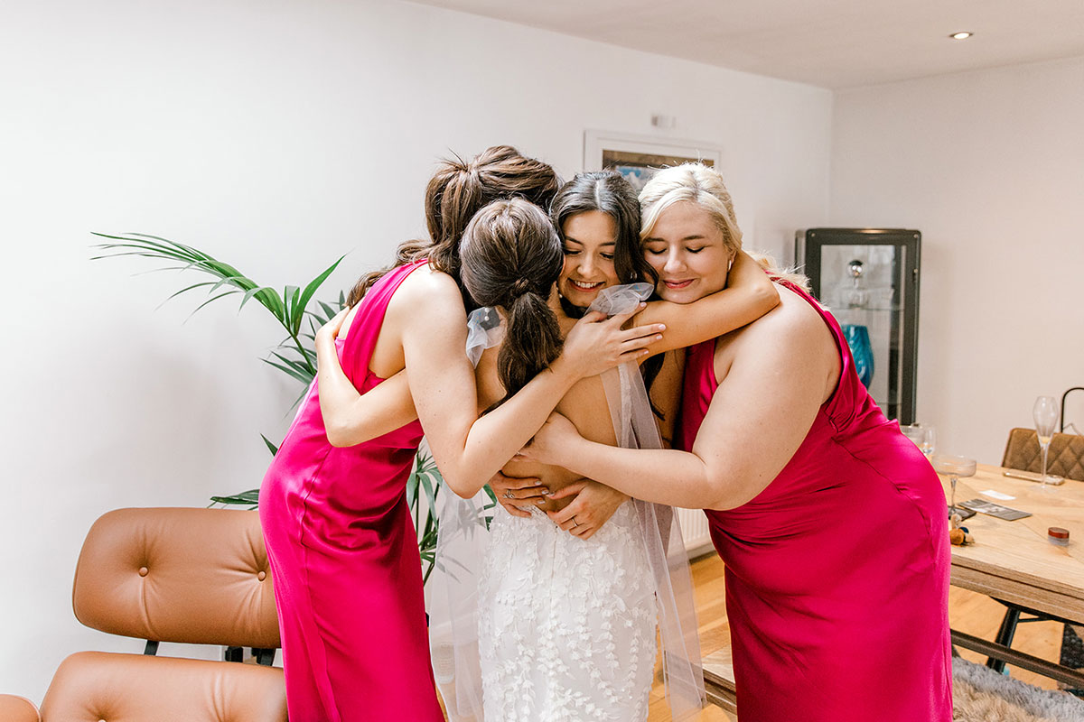 Bride sharing a group hug with her bridesmaids before the wedding ceremony