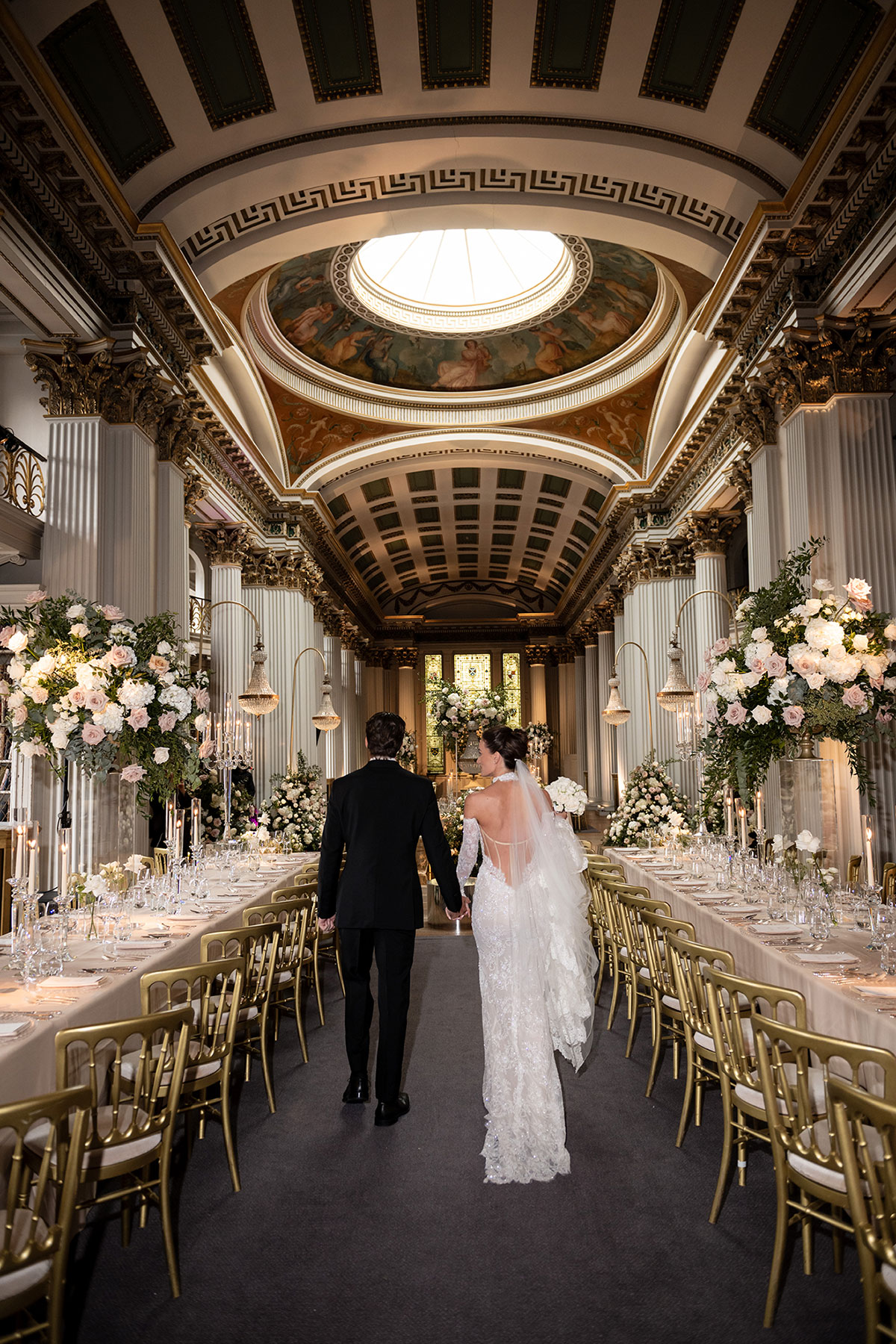 Couple walking through Signet Library reception setup under dome ceiling