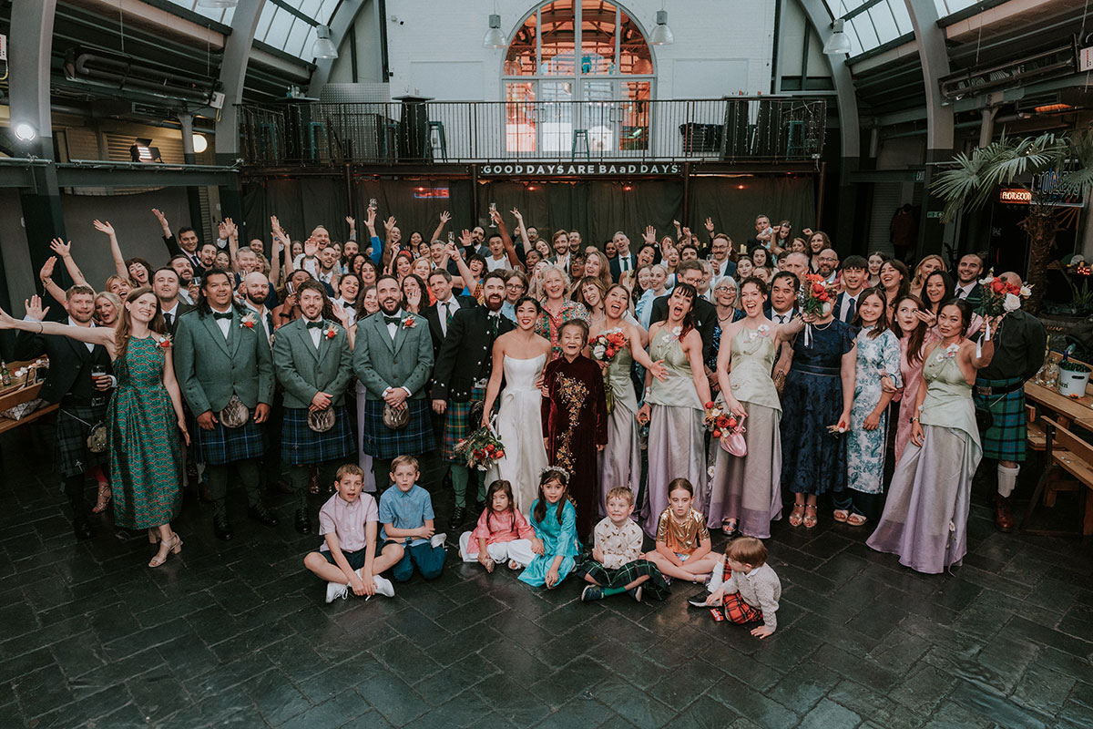 Large wedding group photo inside Barras Art and Design Glasgow with bride, groom and guests posing