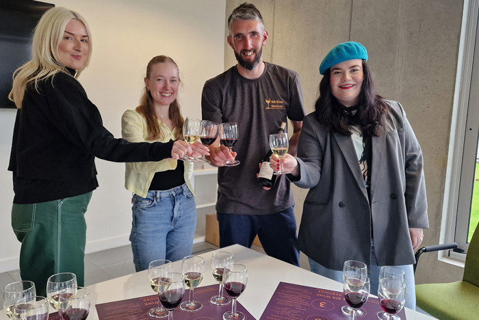 MB Wine Services' Murray with three women holding wine glasses and a wine bottle 