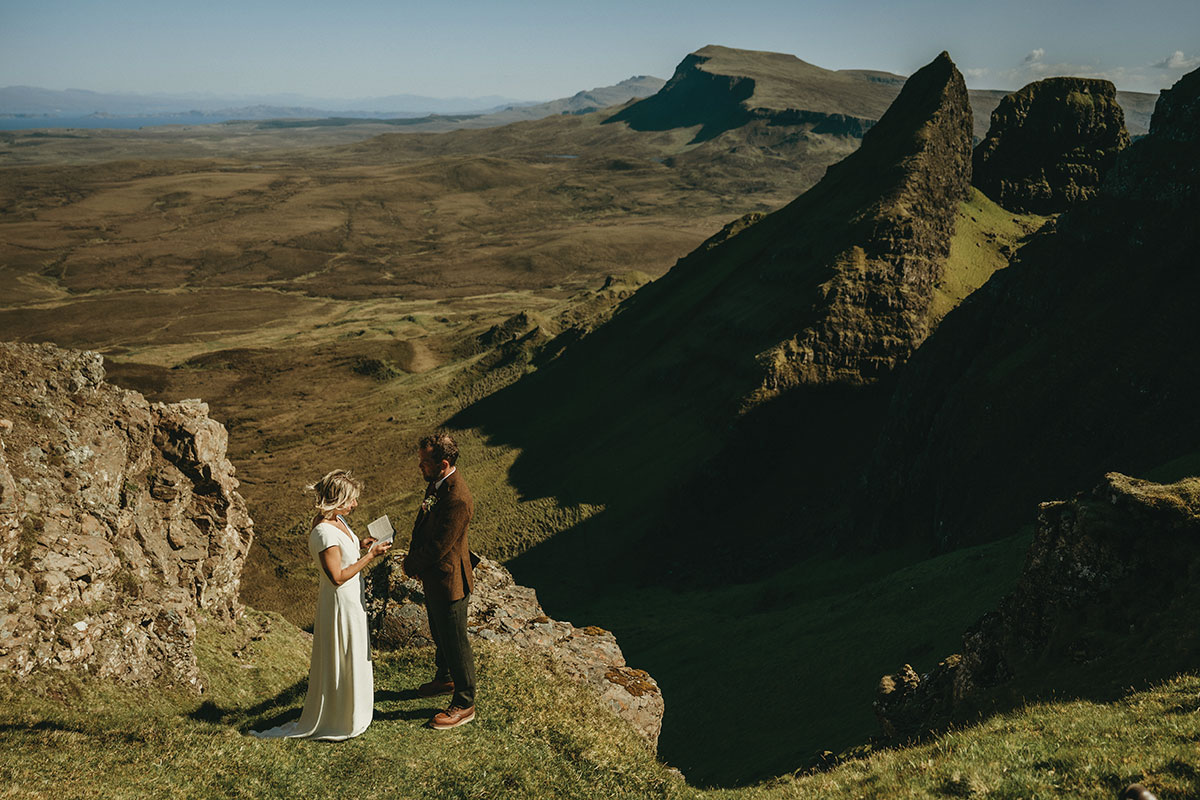 Couple exchange vows on a rocky cliff edge overlooking the dramatic Quiraing landscape on the Isle of Skye during an intimate outdoor ceremony
