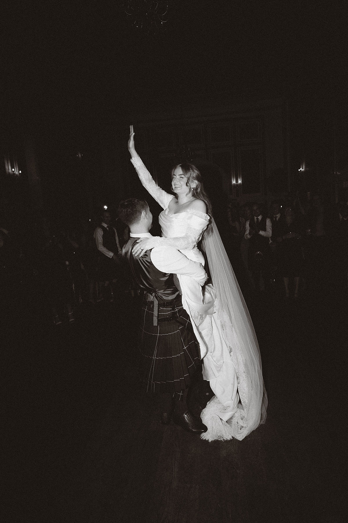 Black and white photo of groom lifting bride during first dance at Scottish wedding reception
