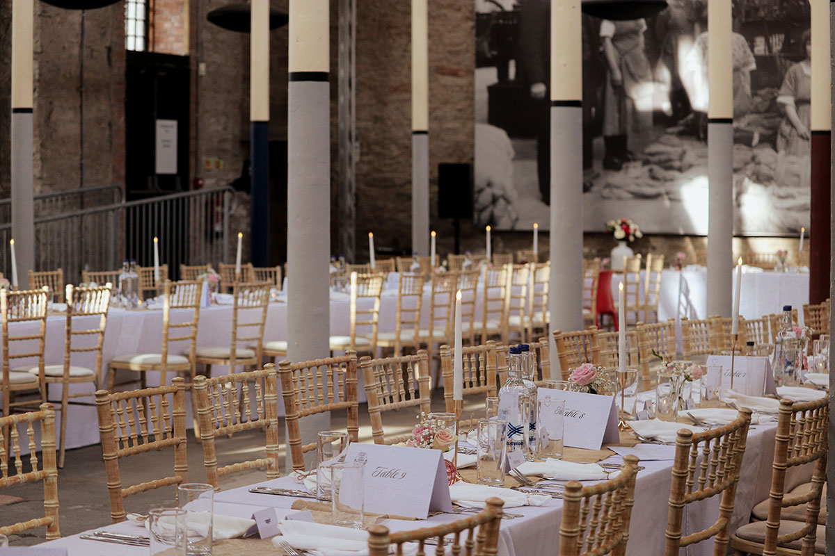 Wedding reception tables set with candles and flowers inside the High Mill at Verdant Works Dundee.