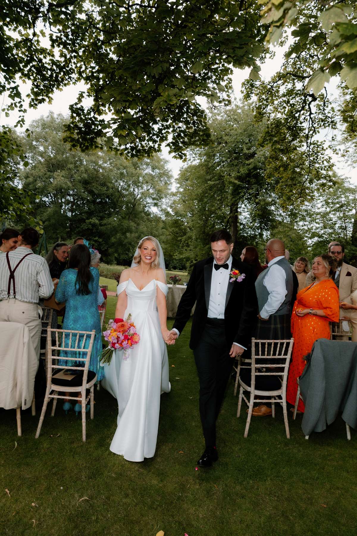 Newlyweds Kara and Rory walk back up the aisle after their outdoor wedding ceremony at Prestonfield House.