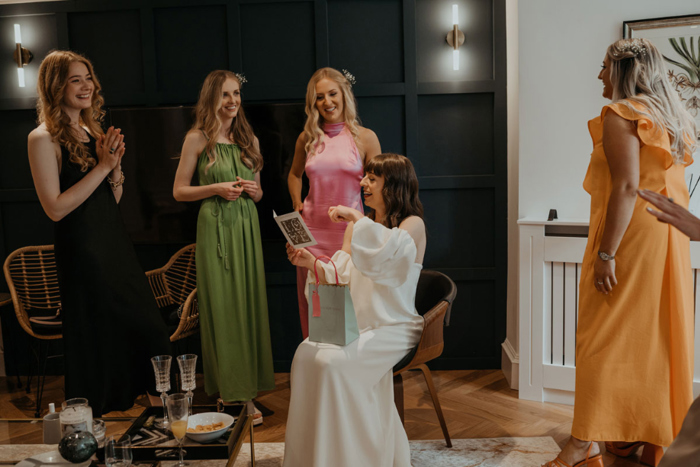 Bride opens a card with her bridesmaids