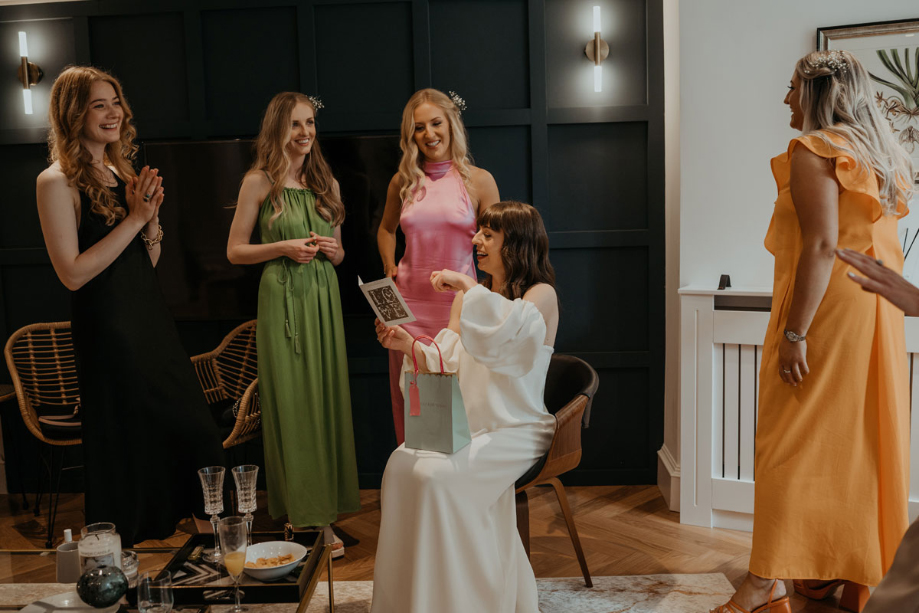 Bride opens a card with her bridesmaids