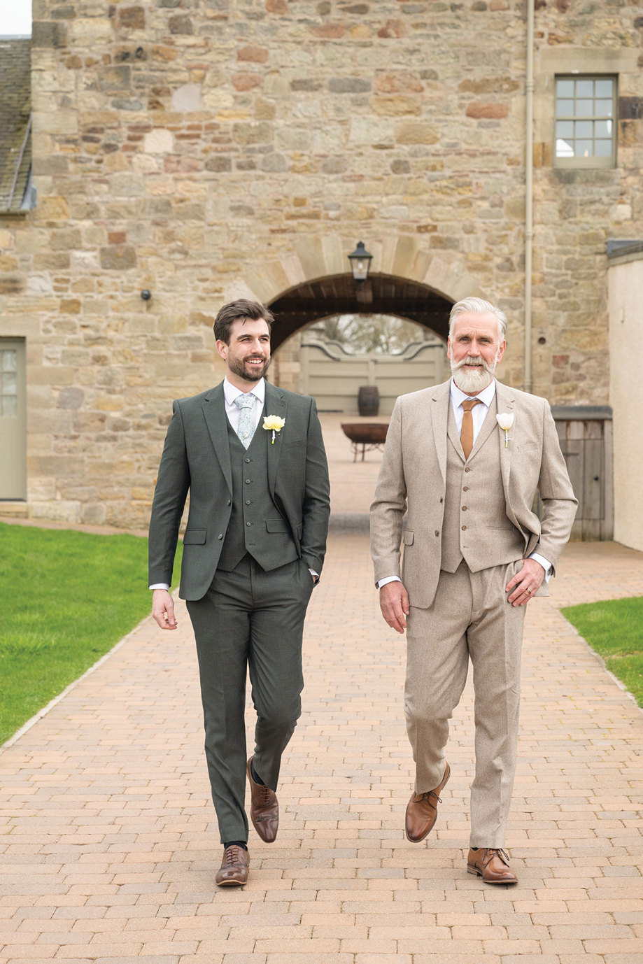 two men walking outside Rosebery Steading wearing fitted suits from Slater Menswear