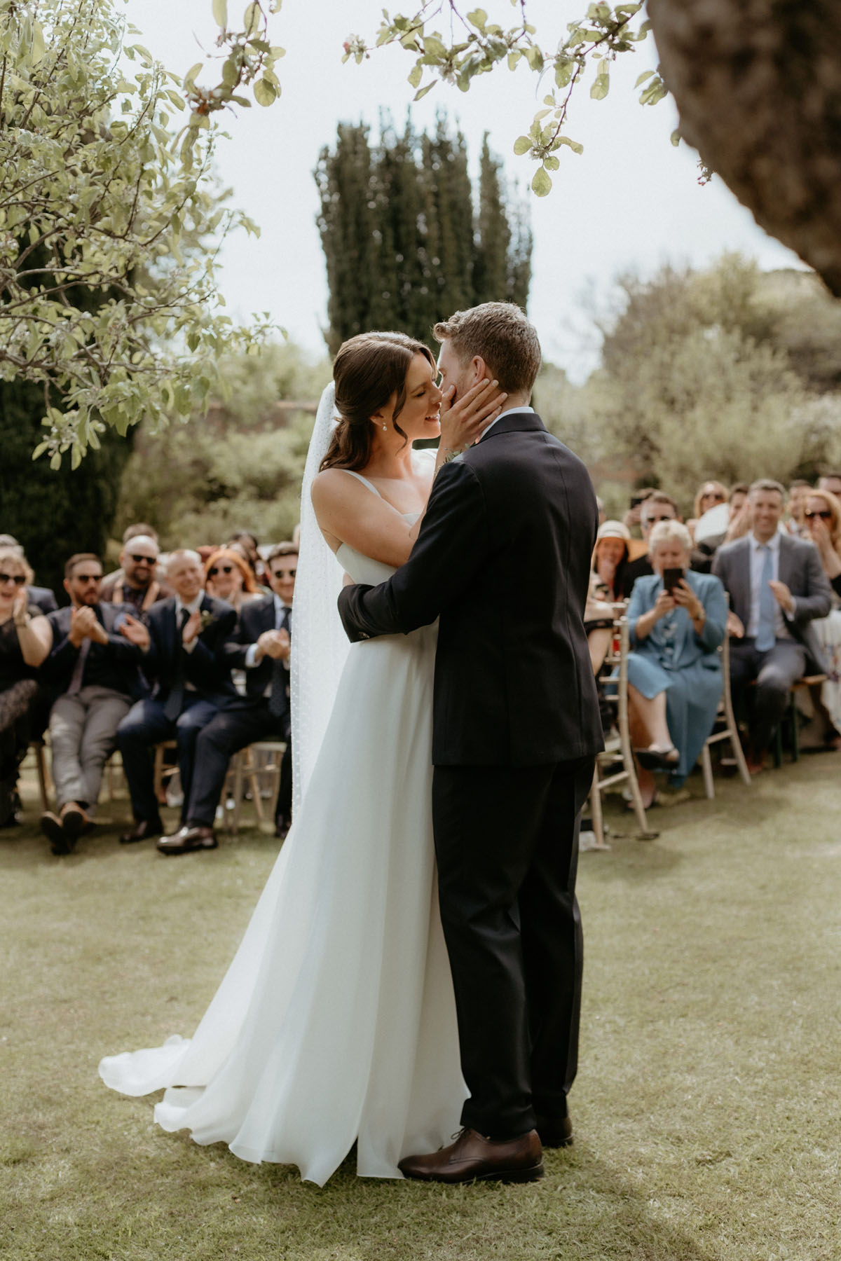 Bride and groom kissing during their outdoor wedding ceremony at The Byre at Inchyra.