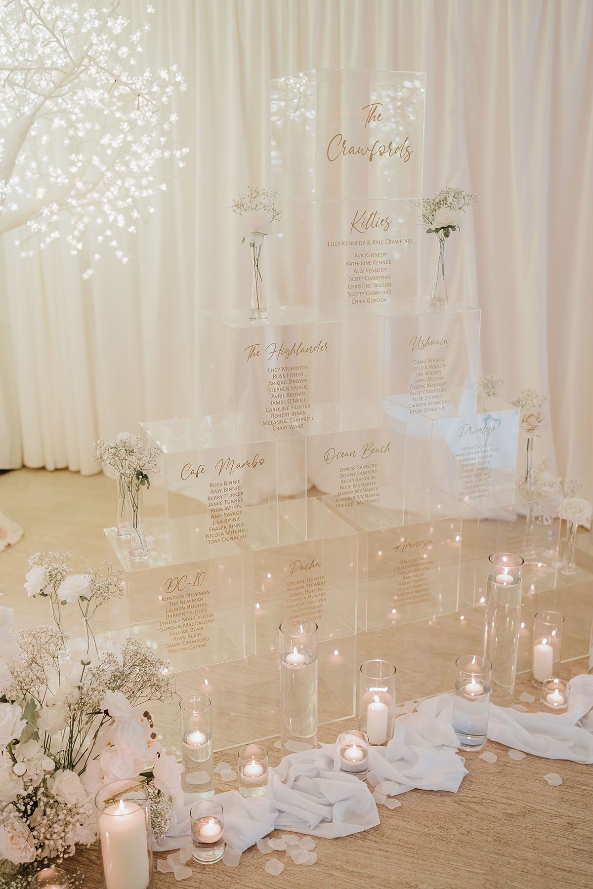 Perspex wedding table plan display with candles, florals and draped fabric at Ingliston Country Club