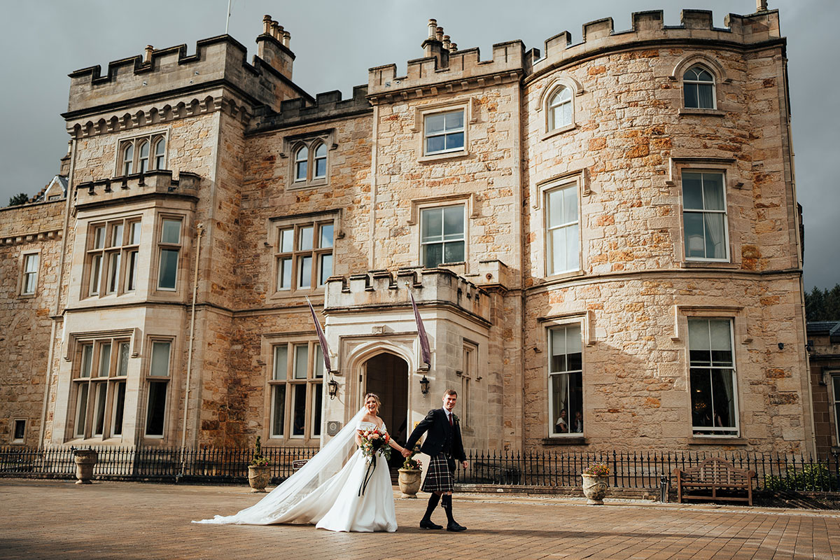 Bride and groom outside the historic Crossbasket Castle wedding venue near Glasgow.