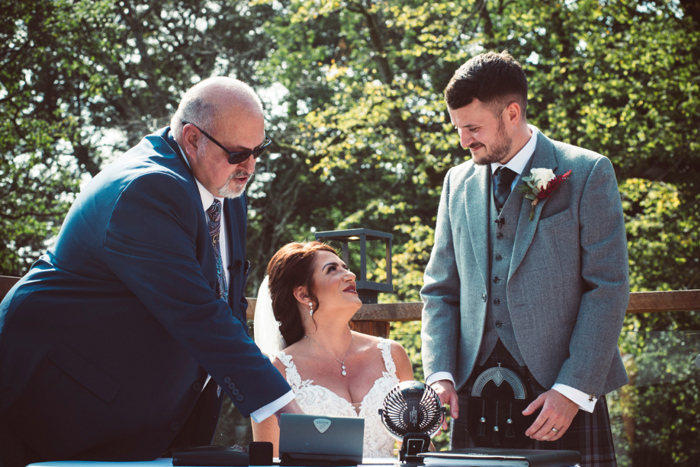 Bride and groom looking at each other as they sign wedding register