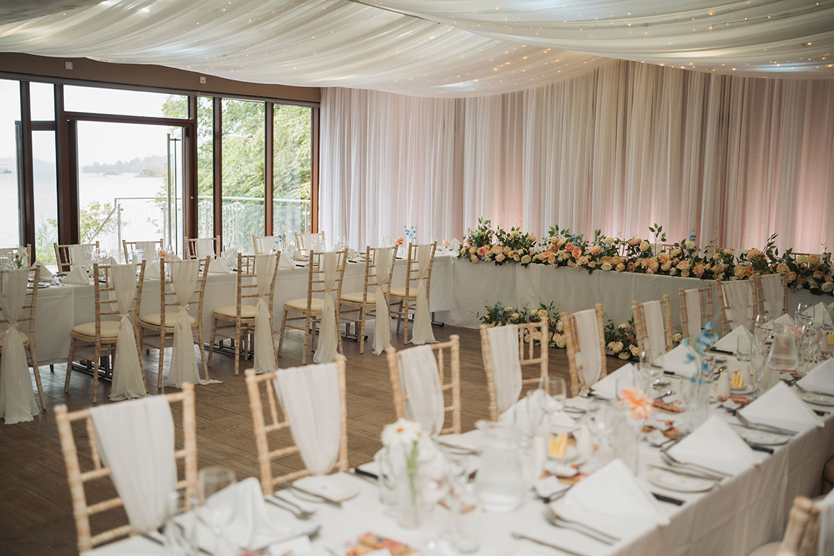 Wedding breakfast setup at Lodge on Loch Lomond with long tables, floral styling and loch views