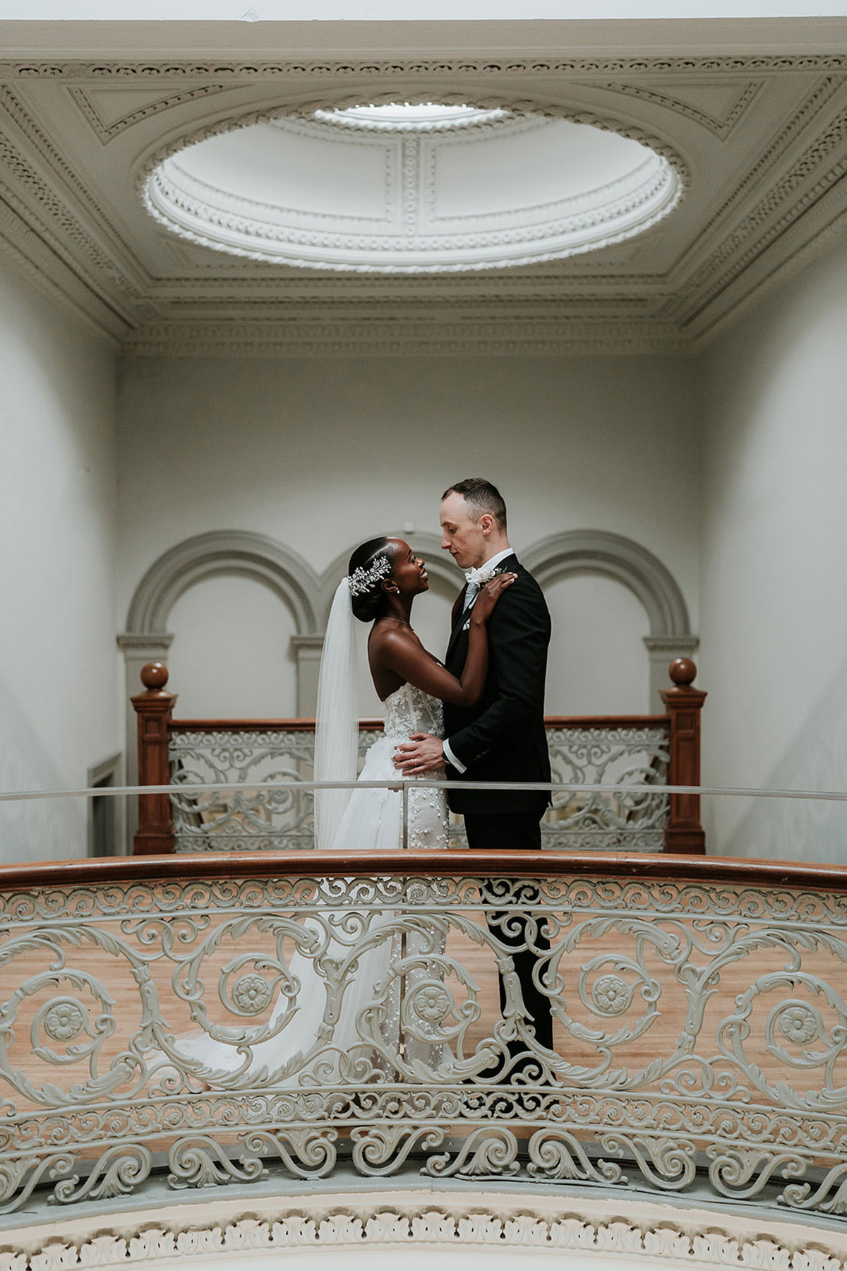 Newlywed couple on ornate balcony inside Kilmardinny House wedding venue in Bearsden