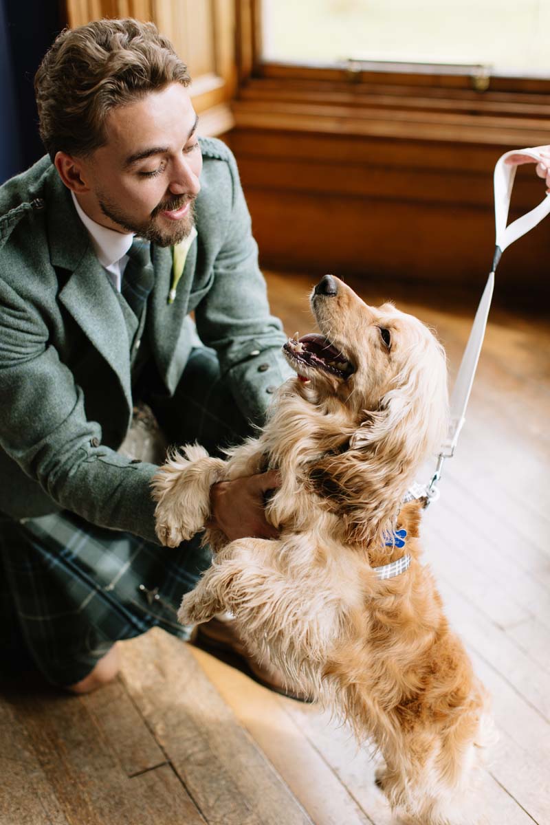 Groom Louis shares a moment with the couple’s cocker spaniel Bertie during their Cambo House wedding.