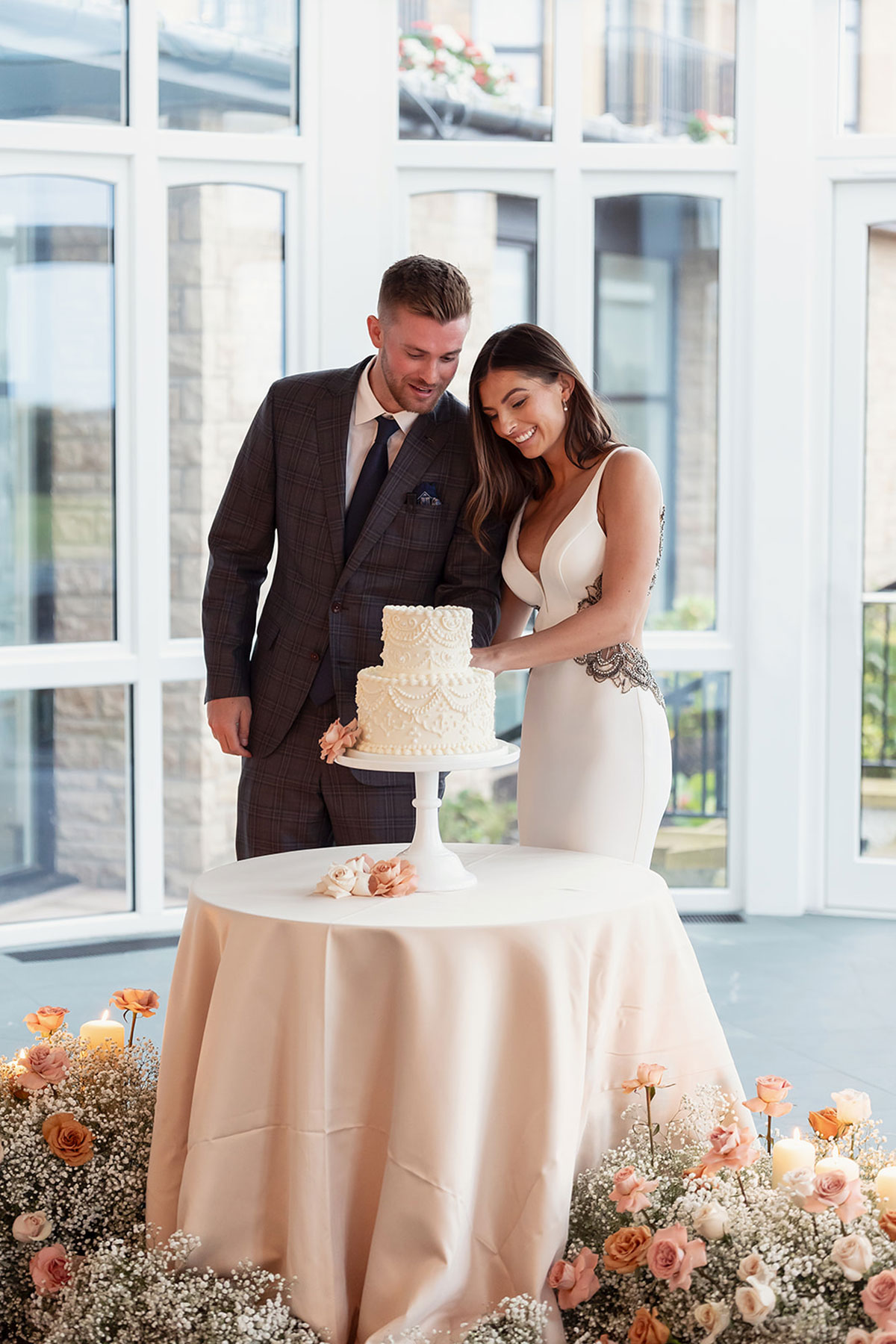 Bride and groom cutting wedding cake together during reception at Old Course Hotel Golf Resort & Spa, St Andrews