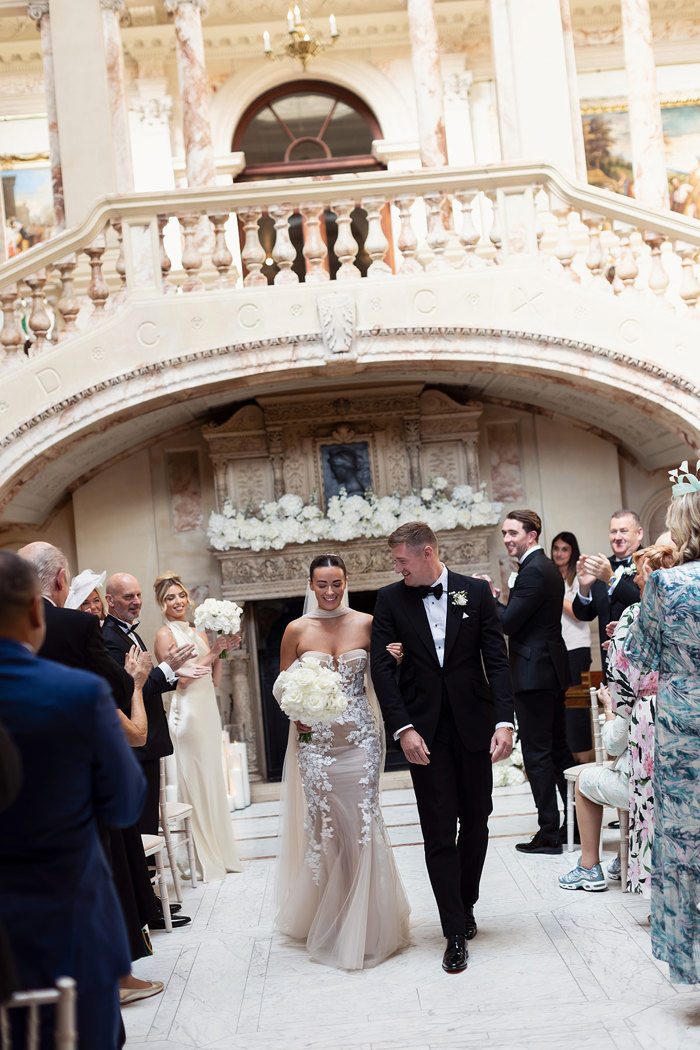 a bride and groom walking down the aisle at Gosford House.