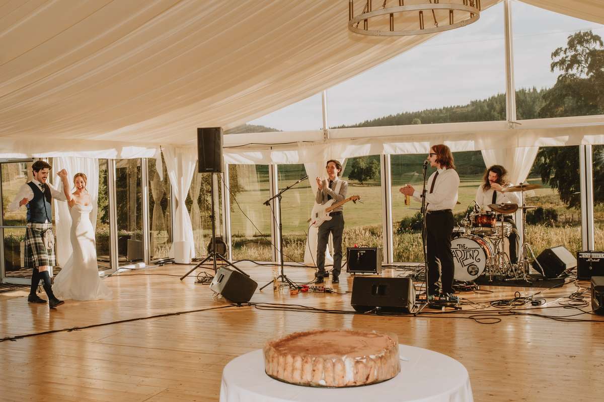 Live wedding band performs inside the marquee as the newlyweds celebrate at Ballogie House
