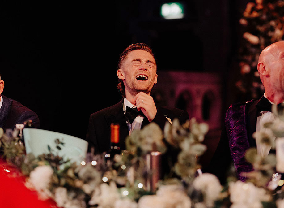 groom laughing wearing tux