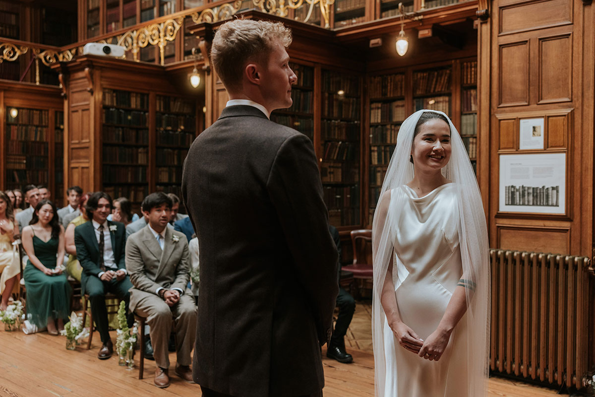 Bride and groom smiling at the altar during their library wedding ceremony.
