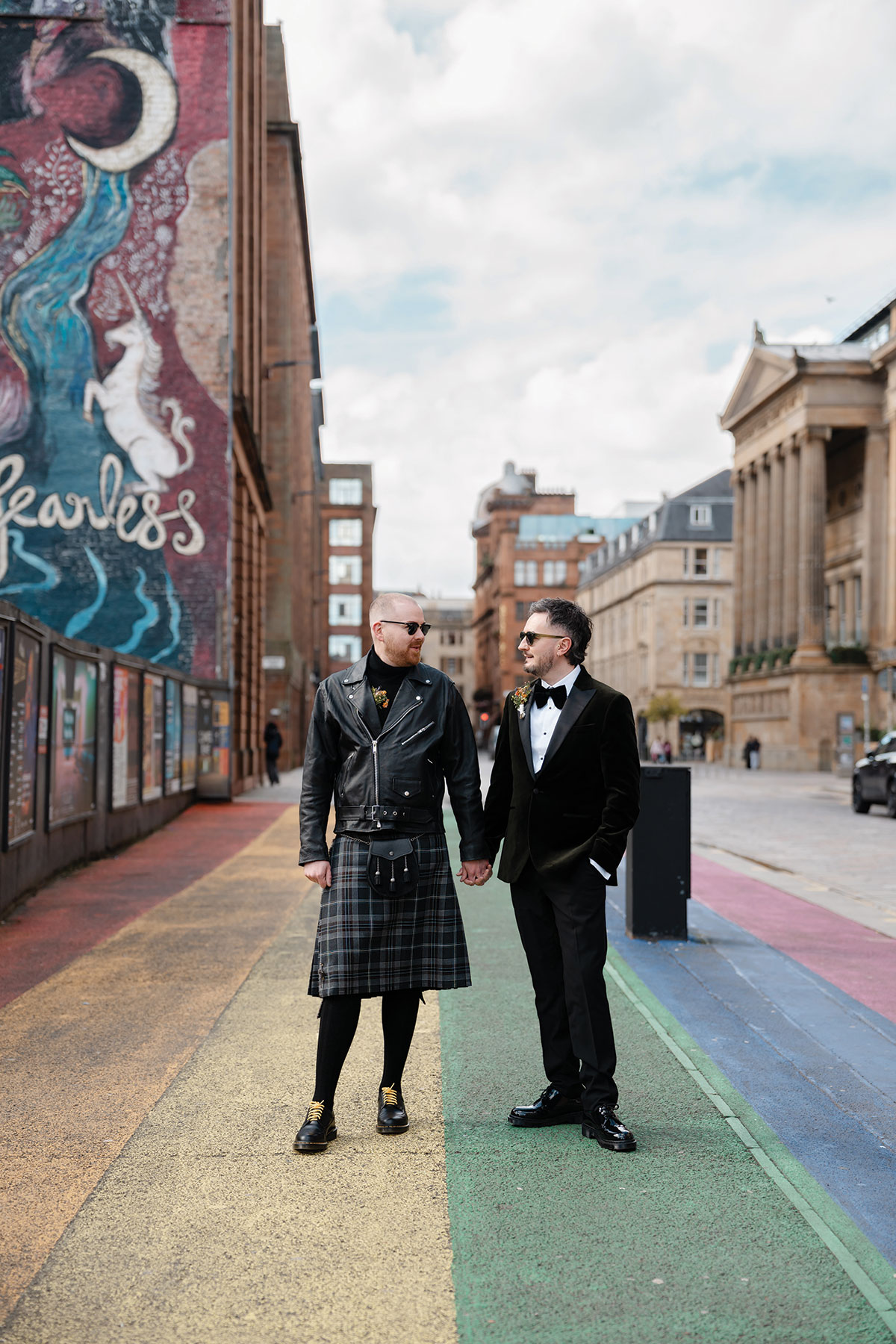 Grooms sharing a portrait on Glasgow's Rainbow Crossing after their city wedding celebration