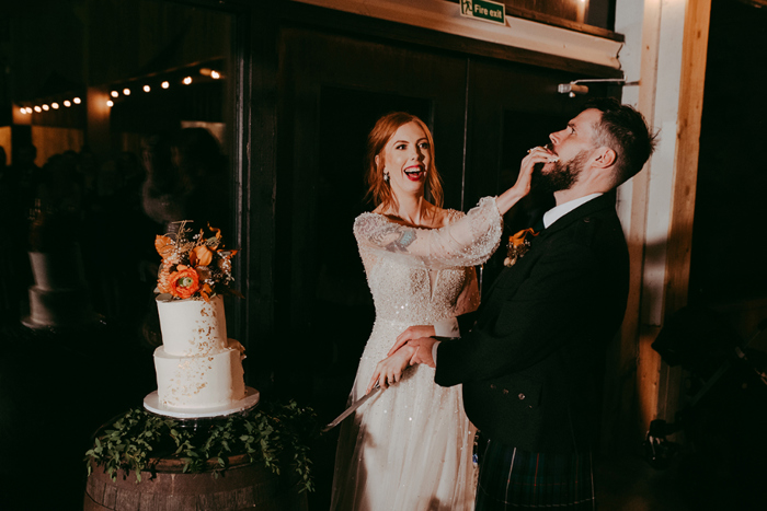 Bride puts cake in groom's mouth during the cake cutting
