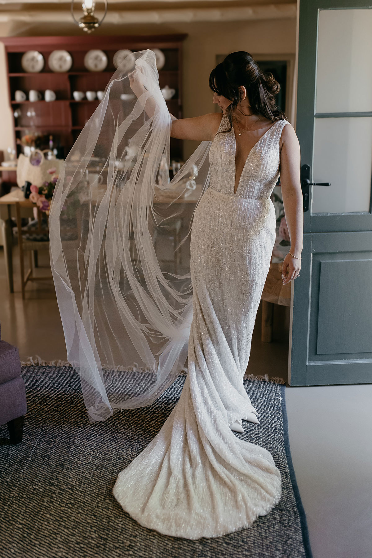 Bride admiring her cathedral-length veil while getting ready for her Boschendal Wine Estate destination wedding in South Africa