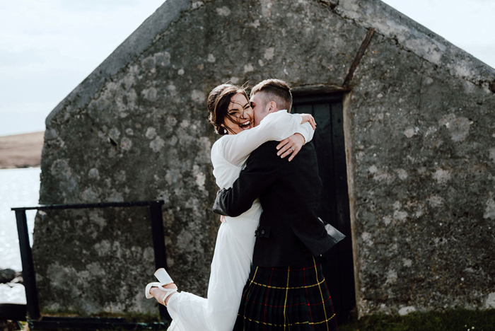 Bride looks thrilled as groom lifts her up