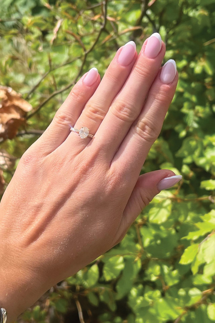 a hand with a diamond engagement ring