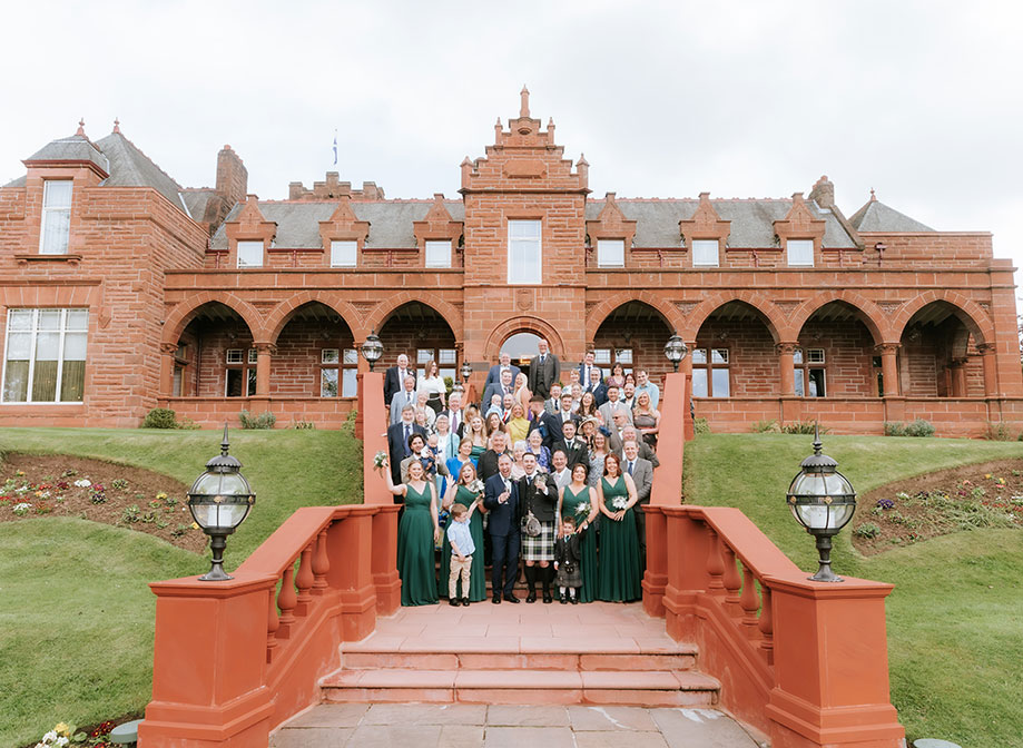 wedding group photo on staircase outside red sandstone exterior of Boclair House