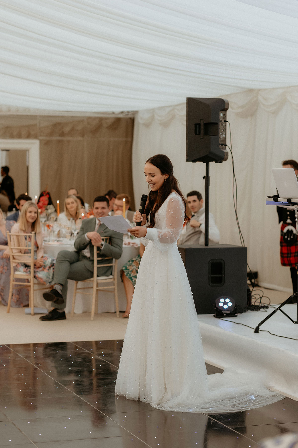 a bride standing holding a microphone while making a speech