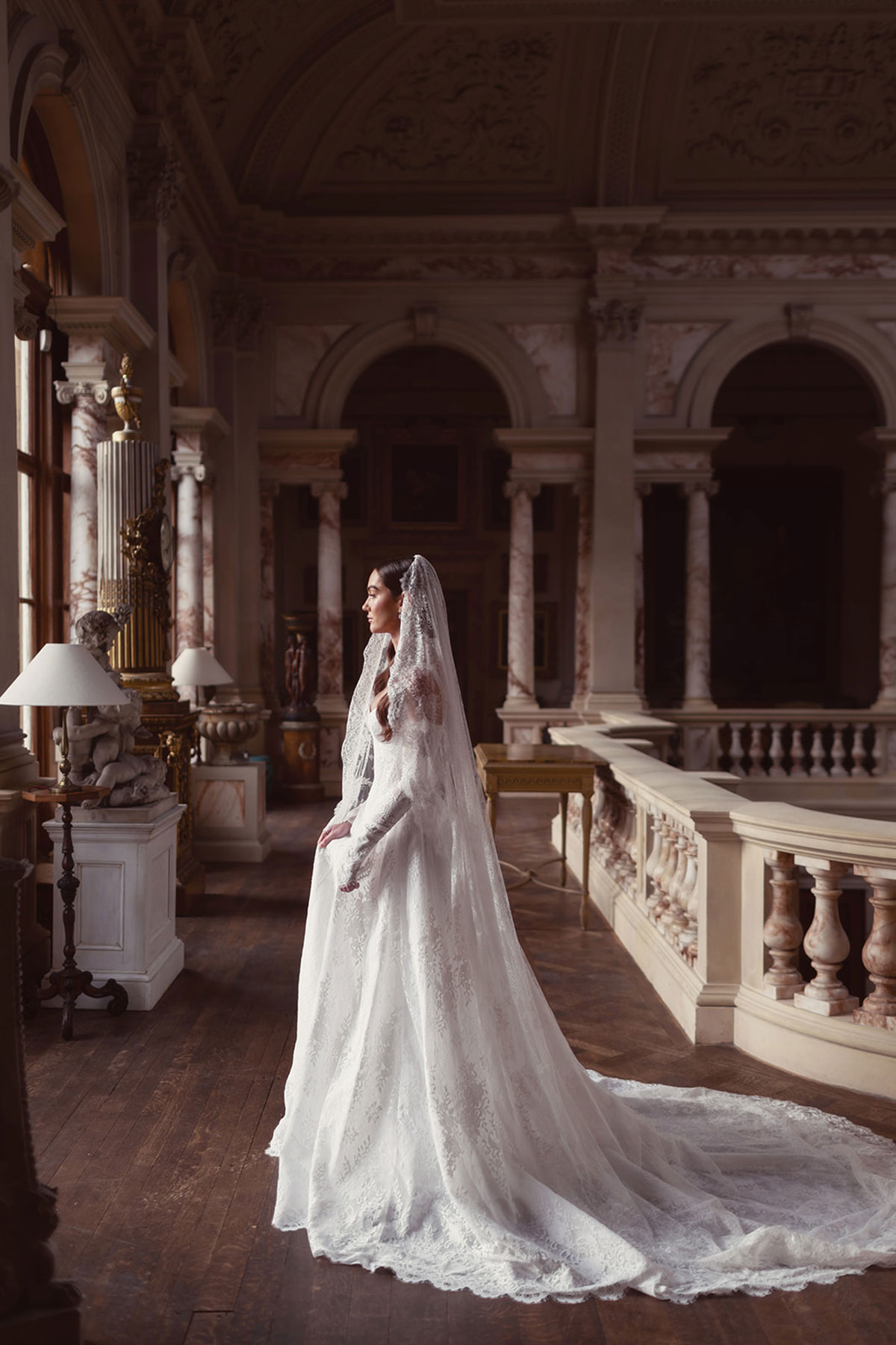 Lace wedding dress styled against the marble balustrade and columns at Gosford House.