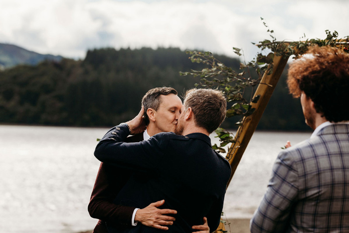 Grooms kiss at the end of their wedding ceremony