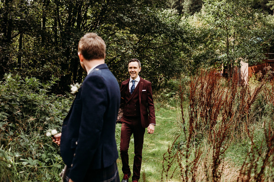 Two grooms do outdoor first look before ceremony